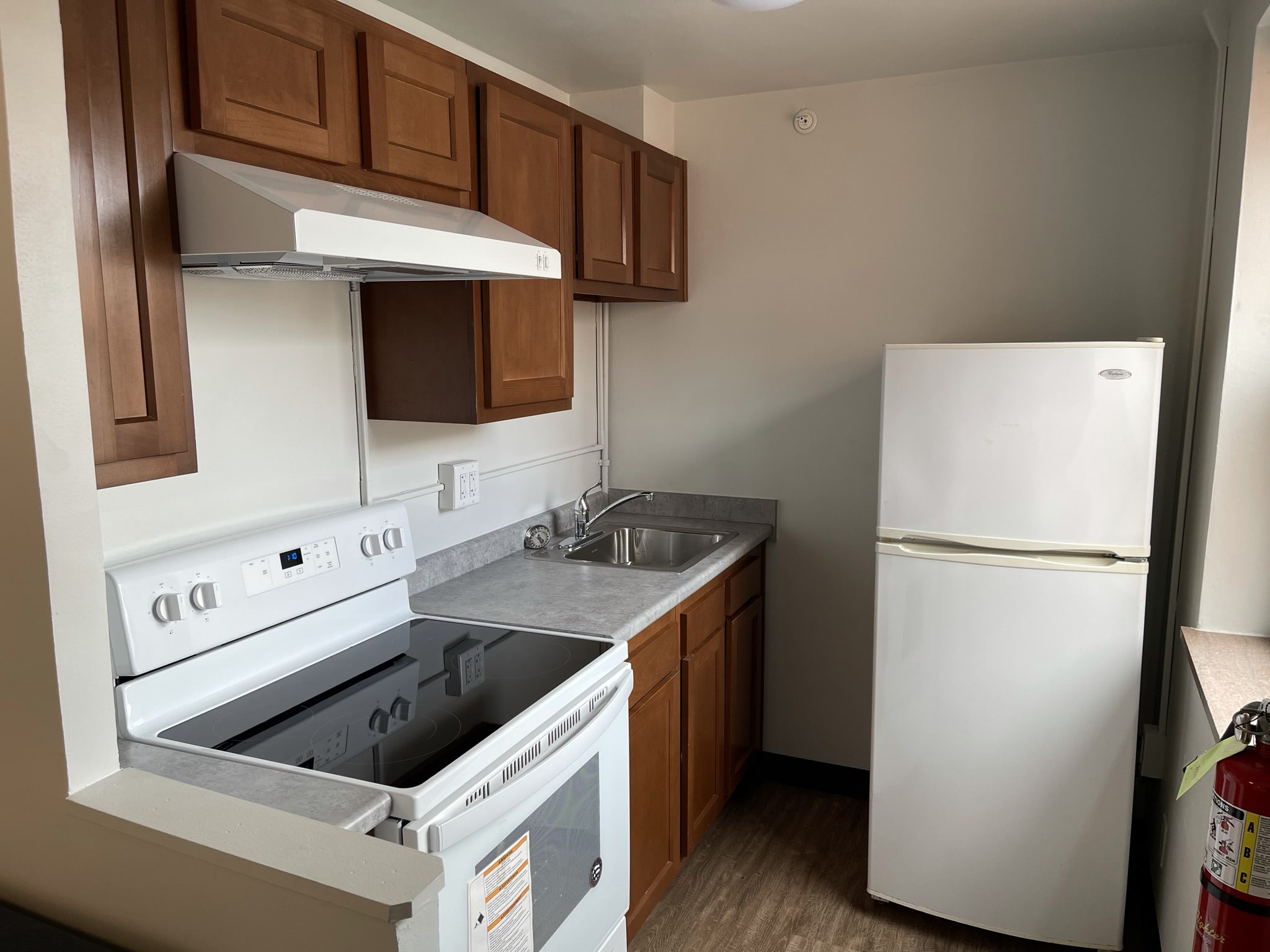 Fifth Neville Studio Apartment Kitchen - stove with overhead exhaust fan, sink, cabinets and refrigerator