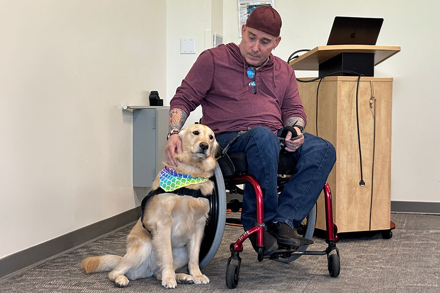 Man petting golden retriever service dog