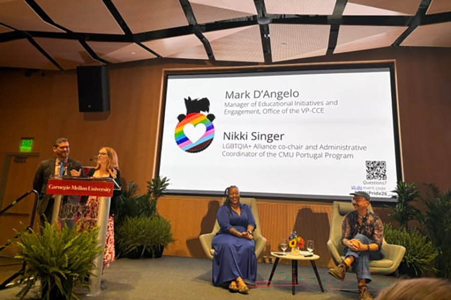 Four presenters in front of slideshow at Pride Celebration