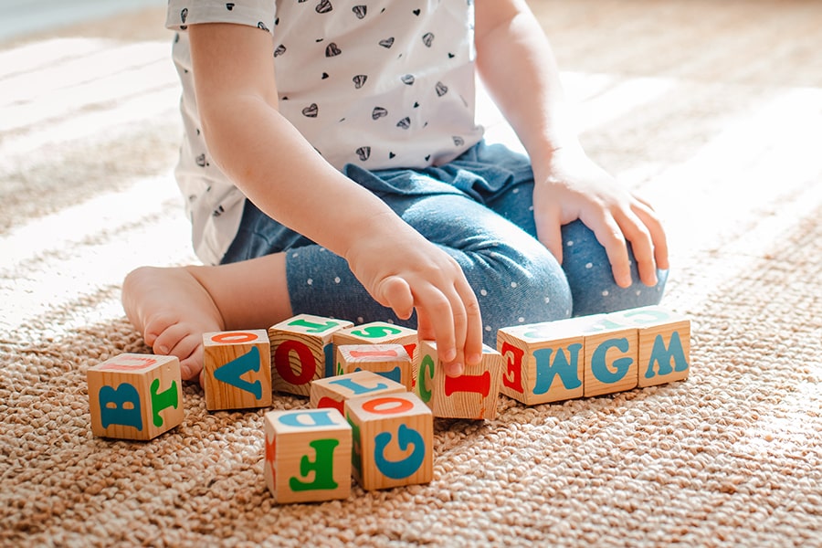Small child on floor playing with blocks