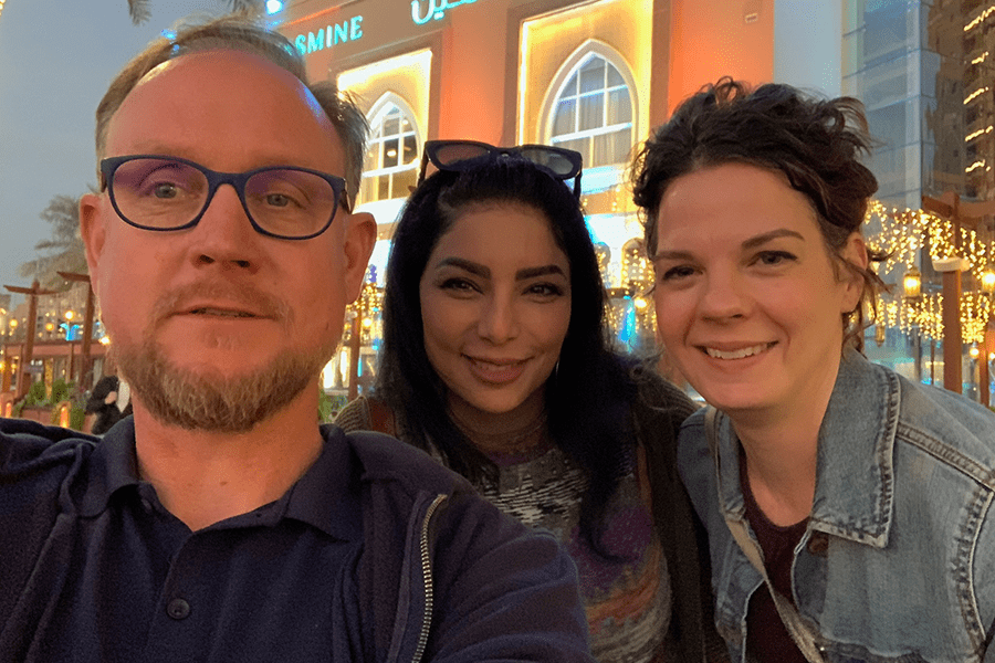 Adam Marks, Dina al Baradee, and Heidi Bachner with Doha nightlife in the background