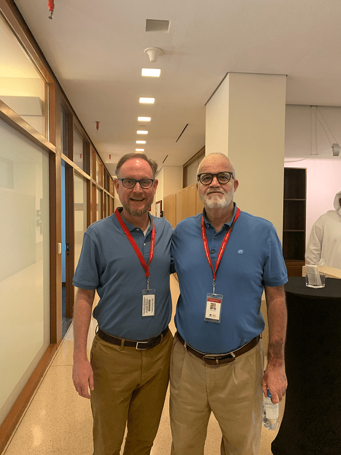 Adam Marks and Taher Giaedi, both dressed in blue polo shirts and khaki pants