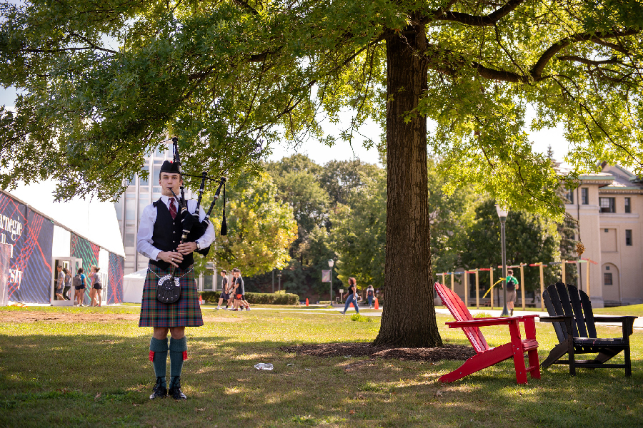 Bagpiper playing on the cut near colorful adirondack chairs