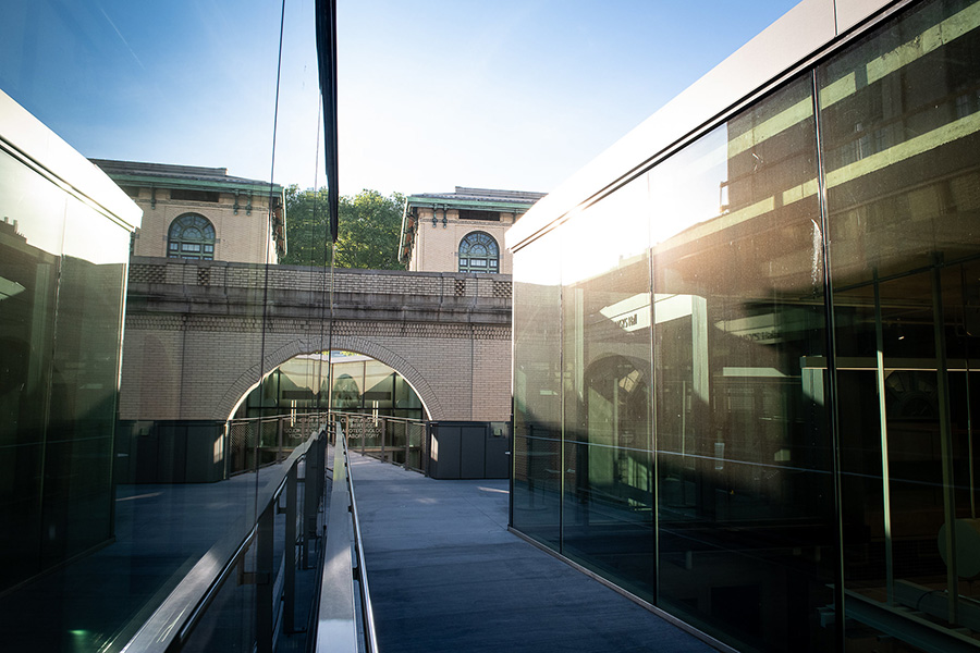 Outdoor walkway running between Ansys Hall and another building; floor to ceiling windows reflect the light.