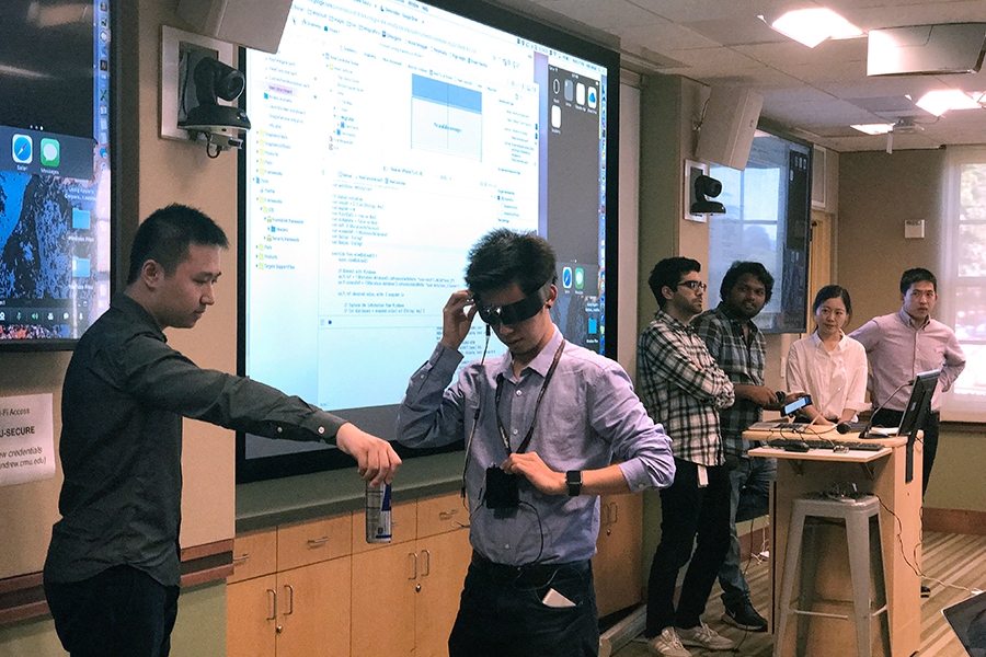 A student is testing out the Snapberry device by wearing the glasses and walking in front of his peers