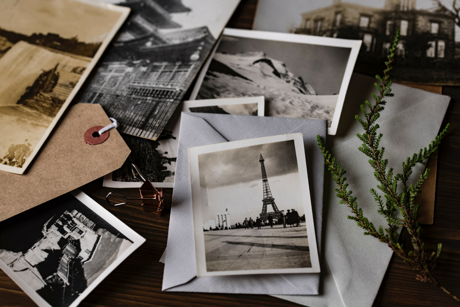 A collection of black and white photos scattered on the ground.
