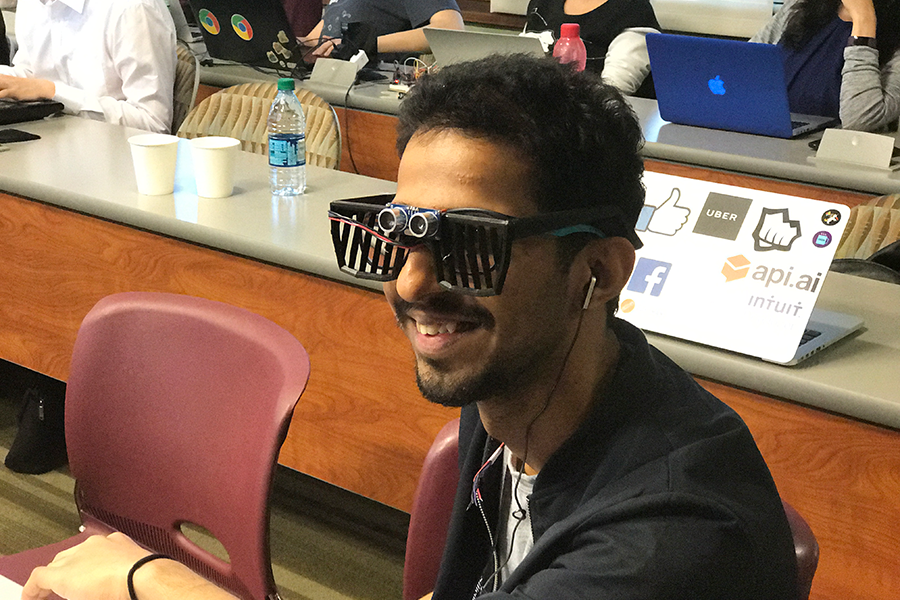 A student is smiling and trying on the Snapberry device glasses
