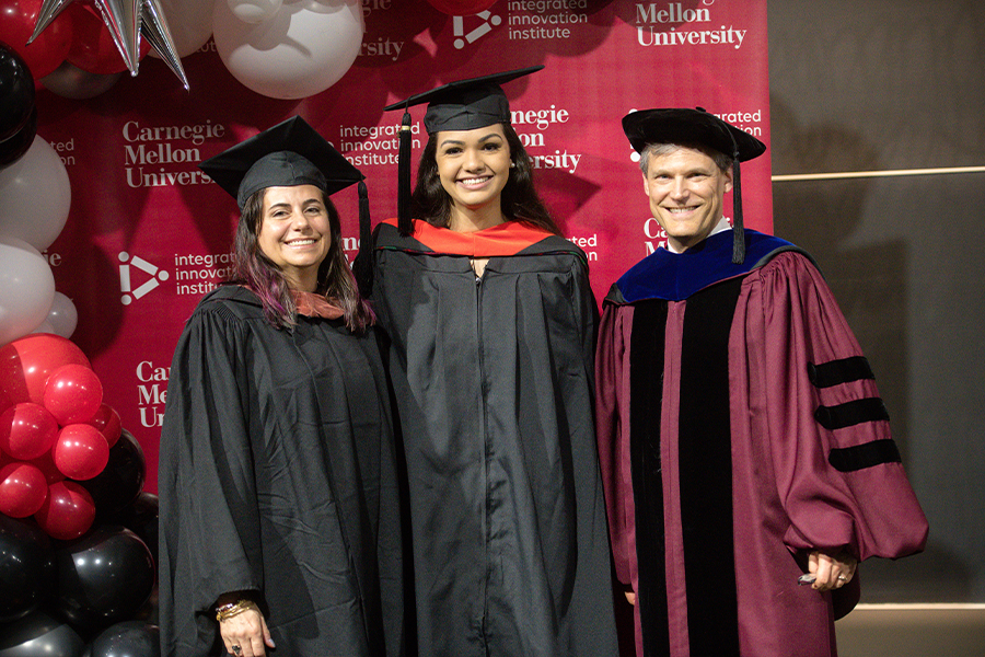 student standing with professors