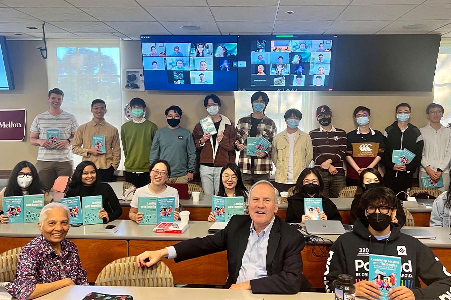 students and professors in class holding books