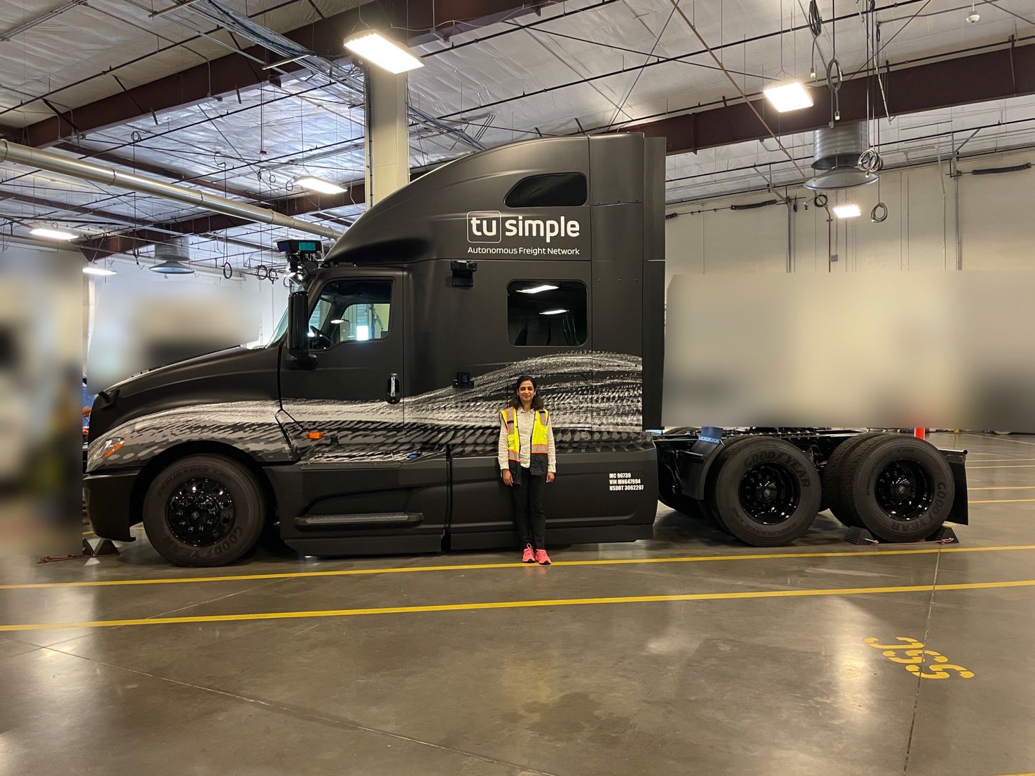 student sukarma parimoo stands in front of an autonomous truck at the TuSimple headquarters in Arizona