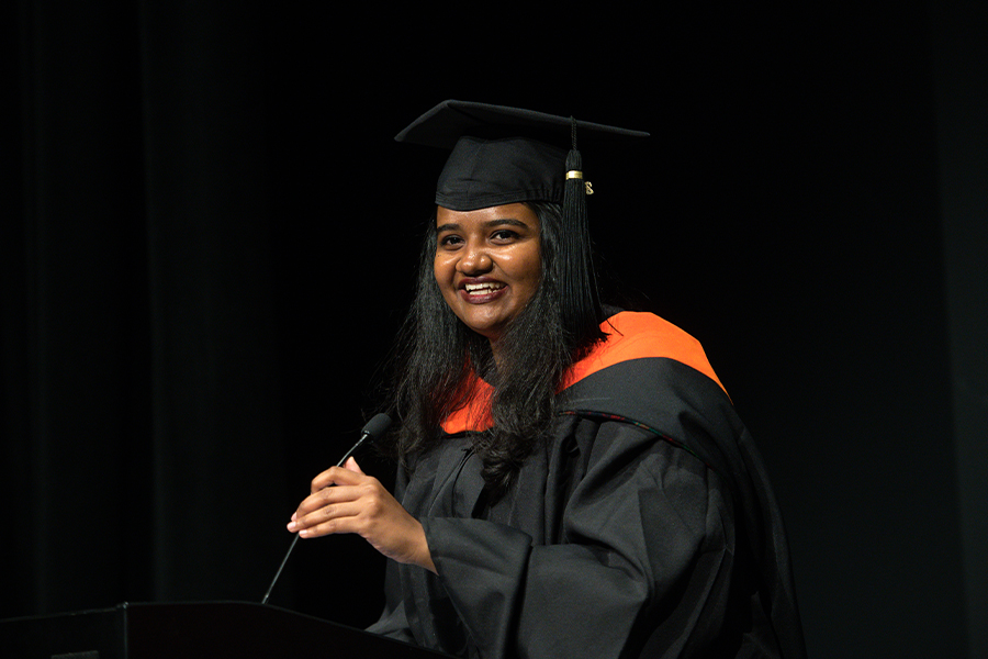 Ananya Madhav speaks into the microphone at the podium