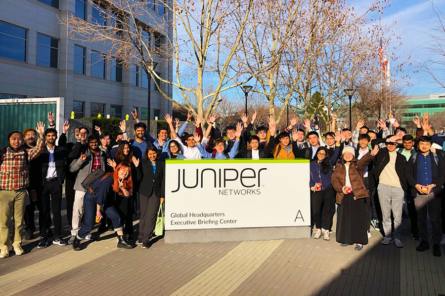 students outside juniper networks building in front of company sign