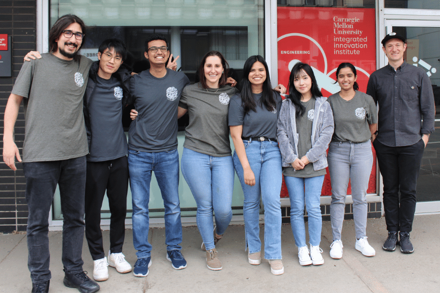 The seven students on Team Ignik pose in front of the Institute's building with project sponsor, Peter Pontano.