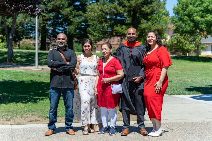 Wearing his regalia, Rasool celebrates his graduation with his family and wife in August 2022