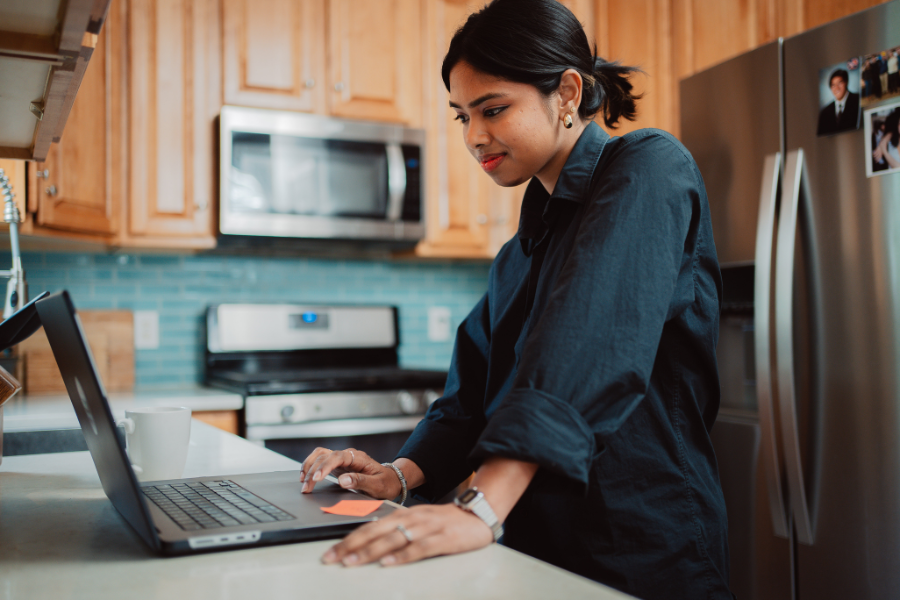 student looking at laptop computer in a kitchen area