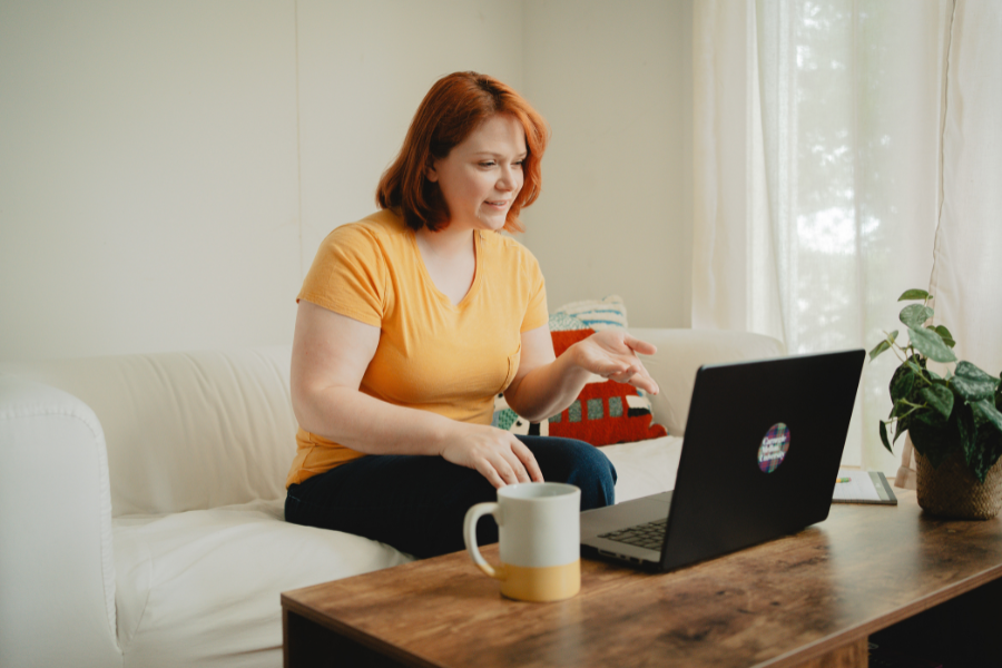 female student with red hair points at laptop computer