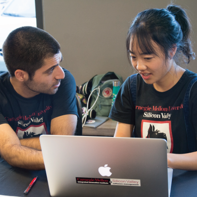 2 cmu students working together at a laptop