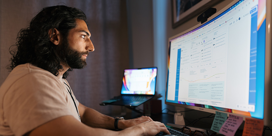 male sits at a computer monitor working on a class assignment for iii online