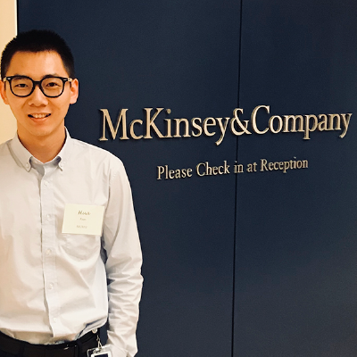 hua fan standing in front of a McKinsey sign