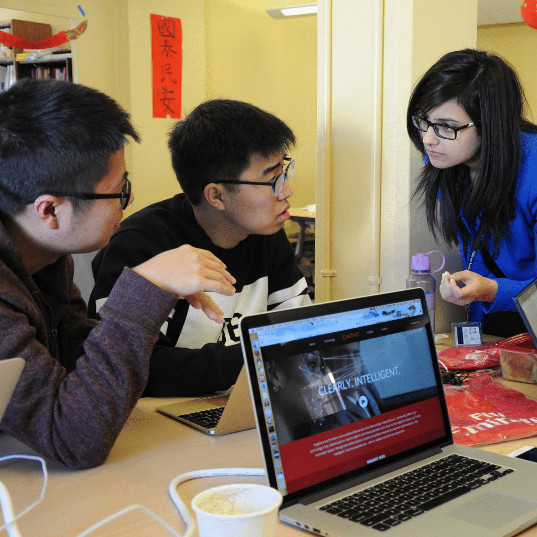 three students discuss a project over their computer