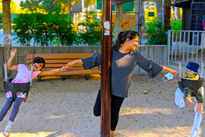 mother, Divya, with her two children on the swings