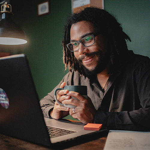 online male student working on a project on a laptop computer smiling, learn innovation