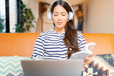 woman sitting at laptop with headphones on