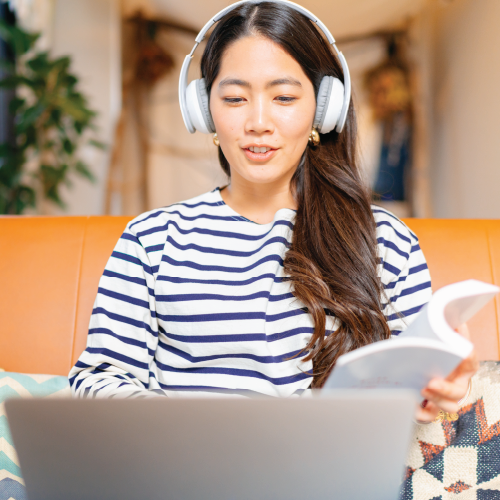 girl sitting at a laptop with headphones