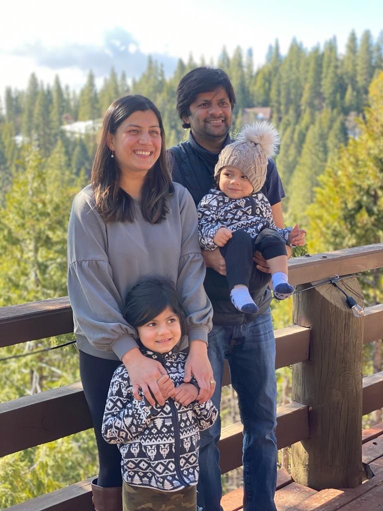 Divya poses with her husband and two children.