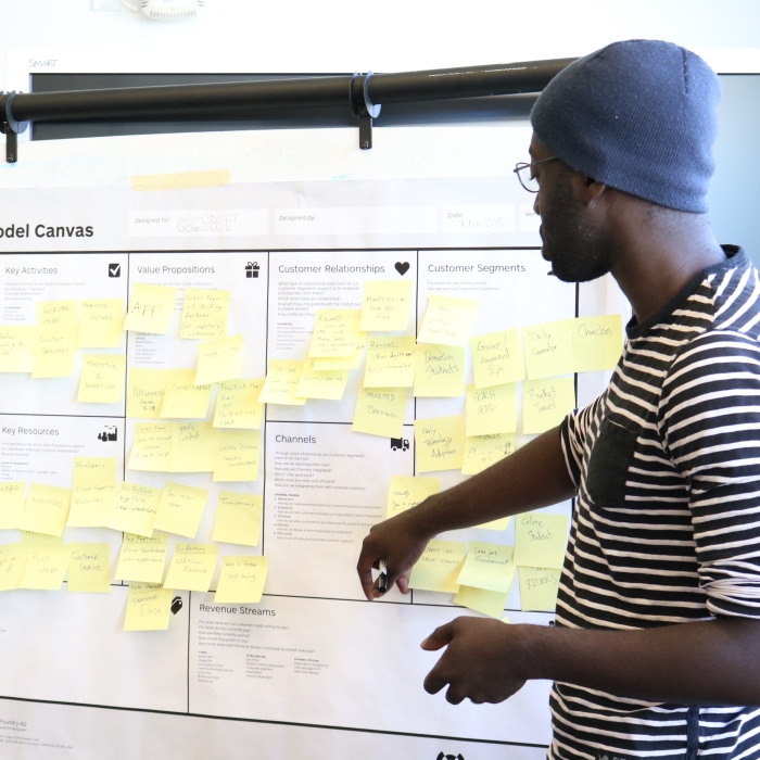 a student at an idea board filled with post its