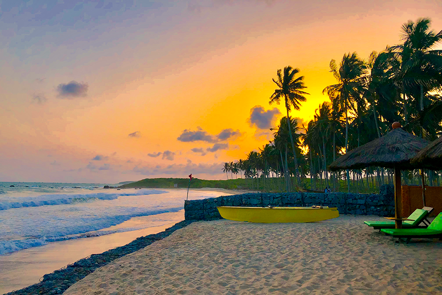 A boat on a beach at sunset