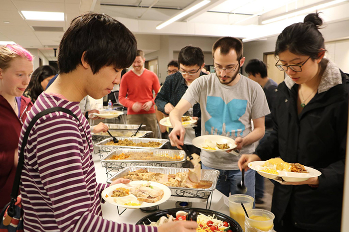 students in line to get food at the potluck