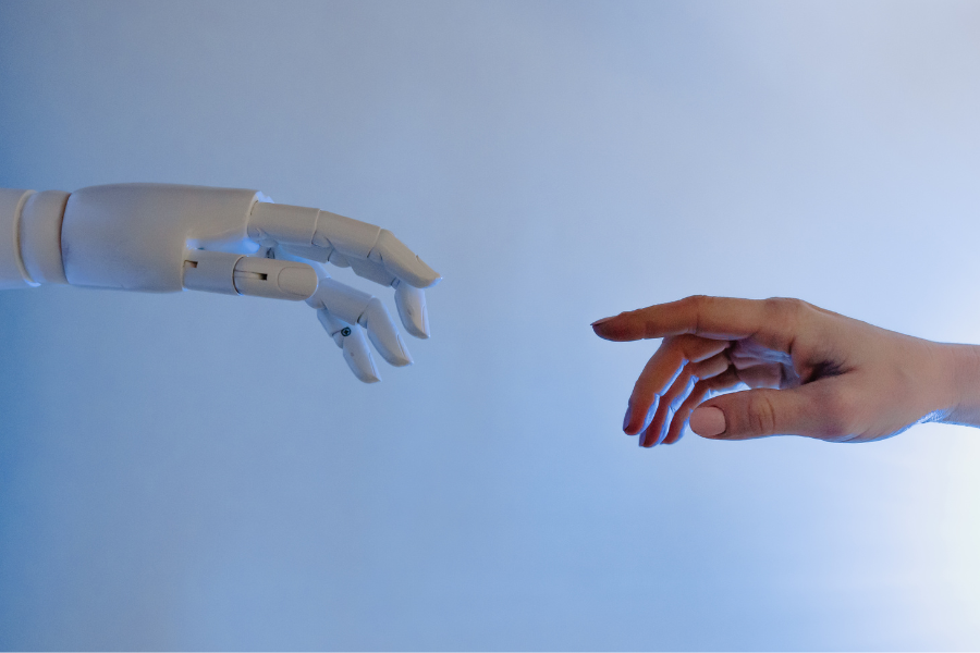 one human hand a mechanical hand reaching for each other