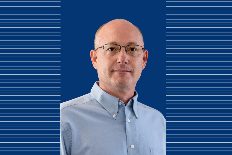 Quinn Jacobson on a blue background with lines beside him