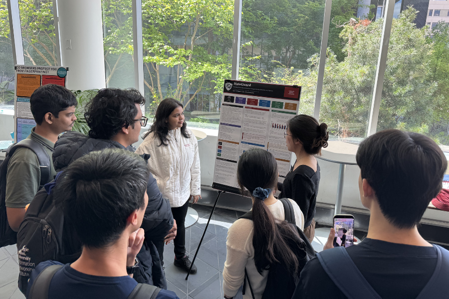 Students presenting a poster at an indoor poster session.