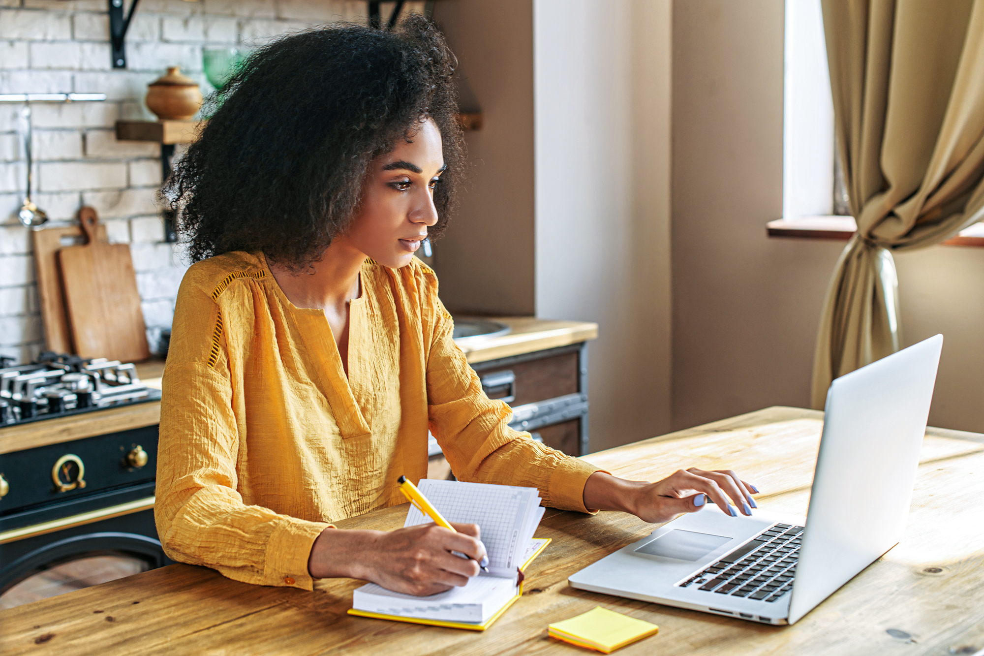 a woman sits at her computer reading the screen