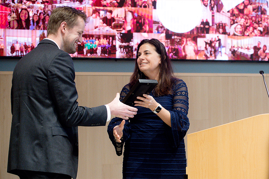 A student accepts an award from their professor