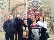 students pose at the berlin wall exhibit of the Newseum in DC.