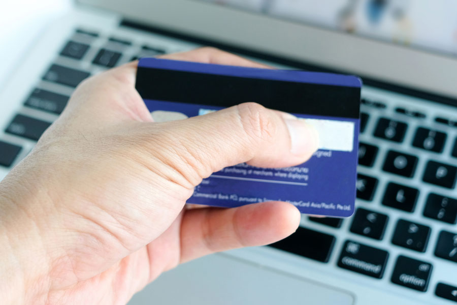 Person looking at the back of a gift card over a computer