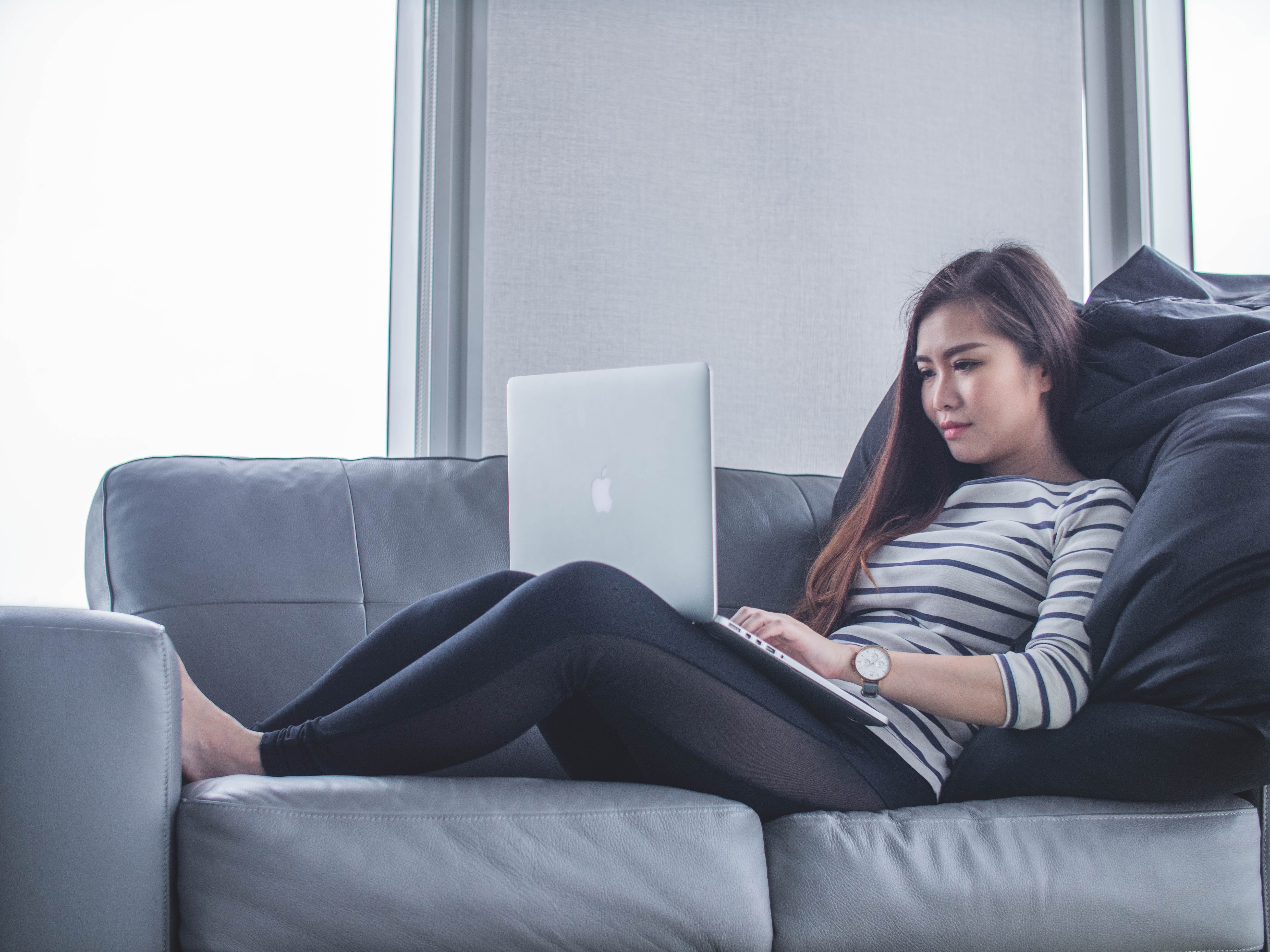 Woman working on computer at home on couch