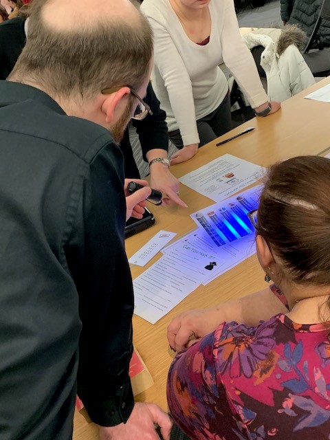 Man uses the blacklight to search for hidden text on a page.