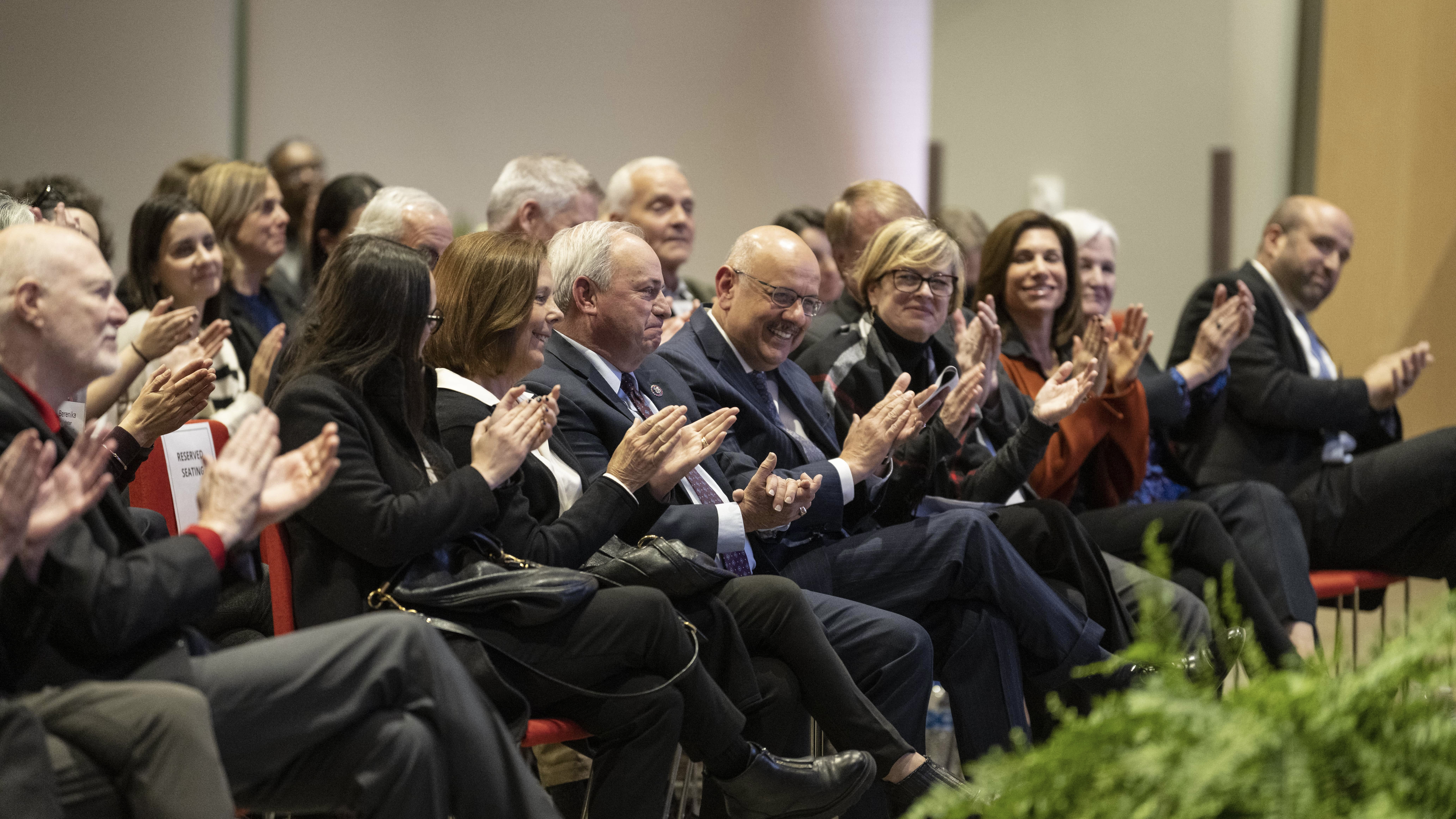 A group of leaders applauds Congressman mike Doyle