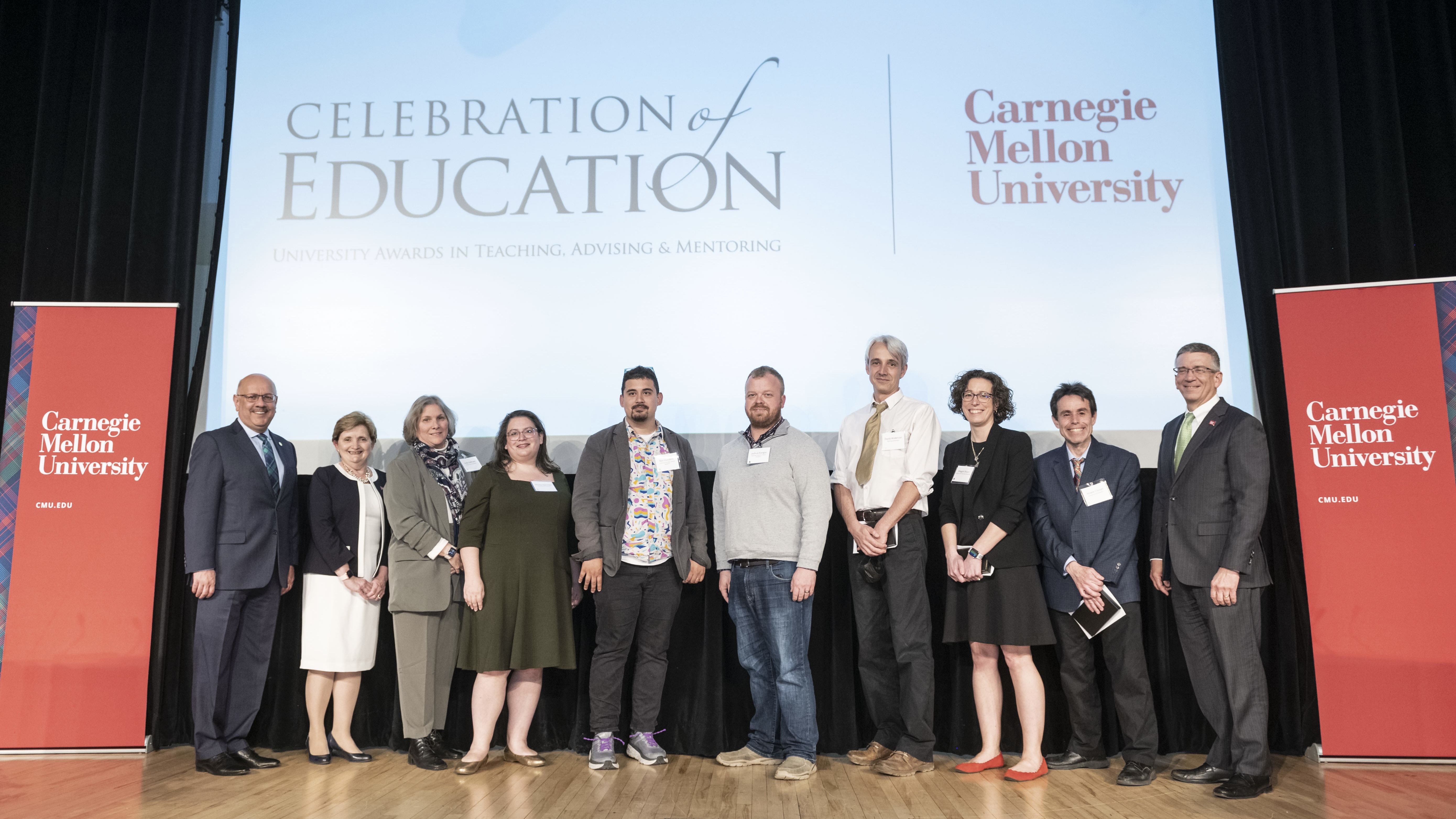 A group of honorees stand together on stage during the Celebration of Education awards ceremony