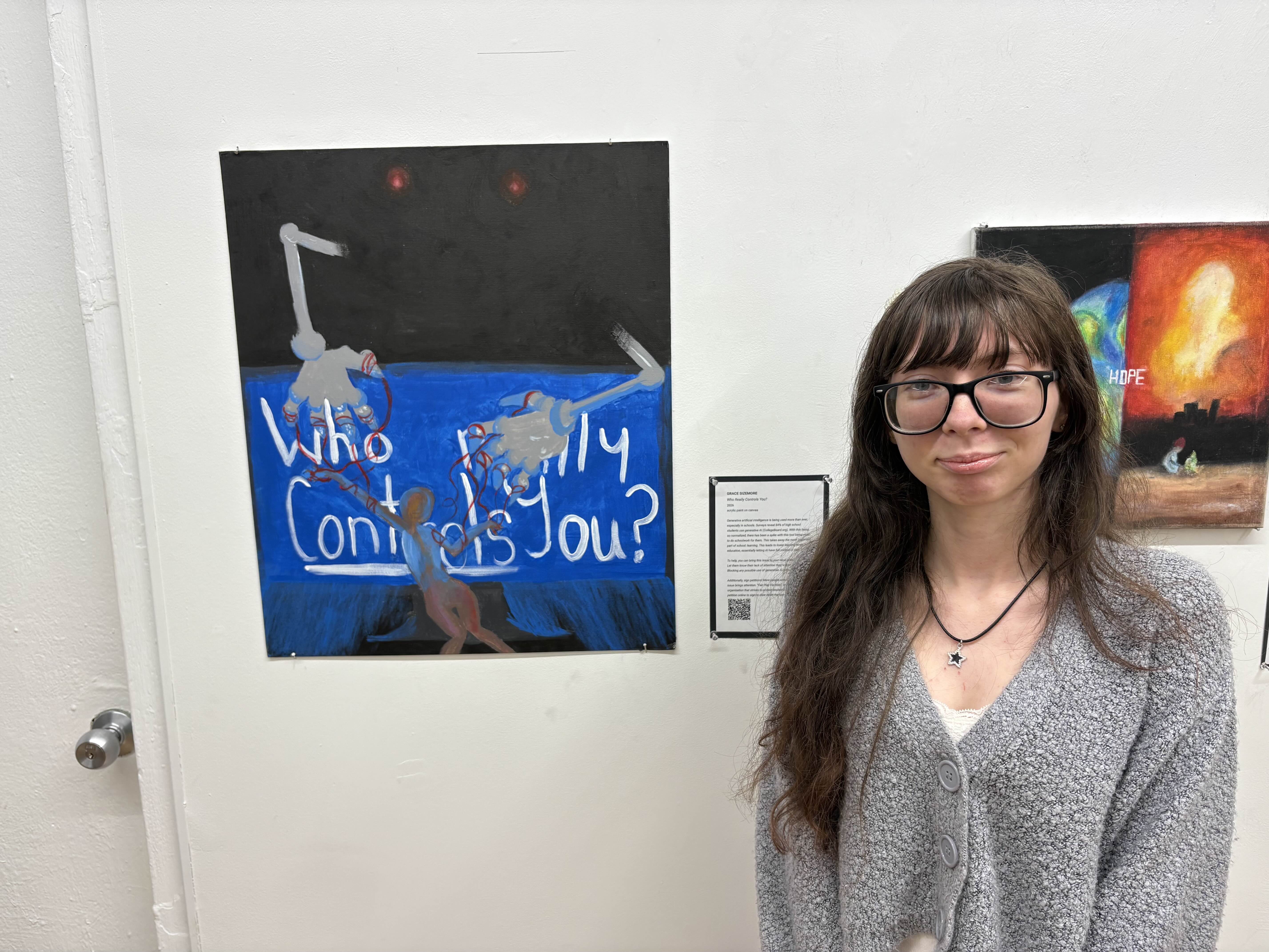Student standing in front of an acrylic painting.