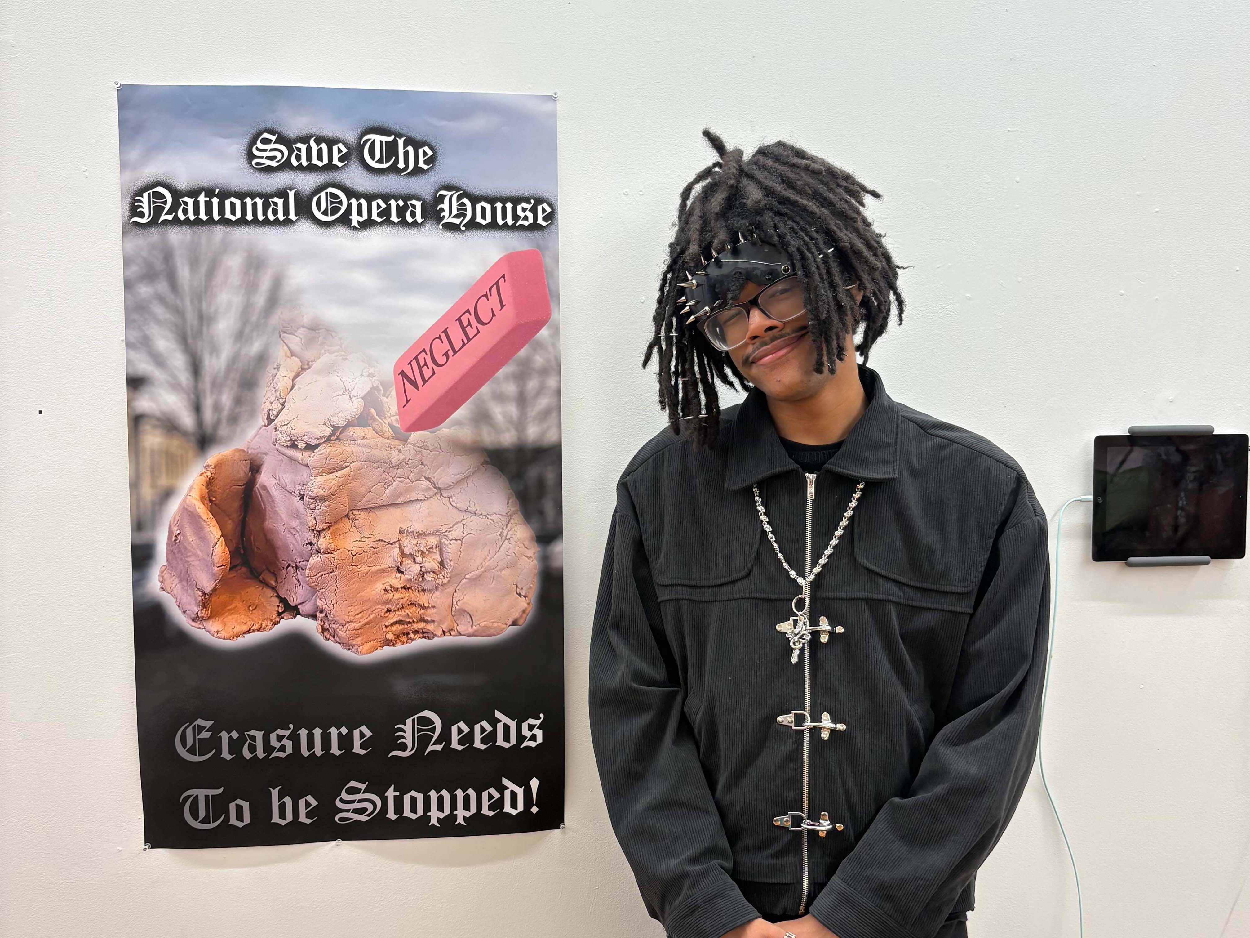 Student standing in front of large poster.