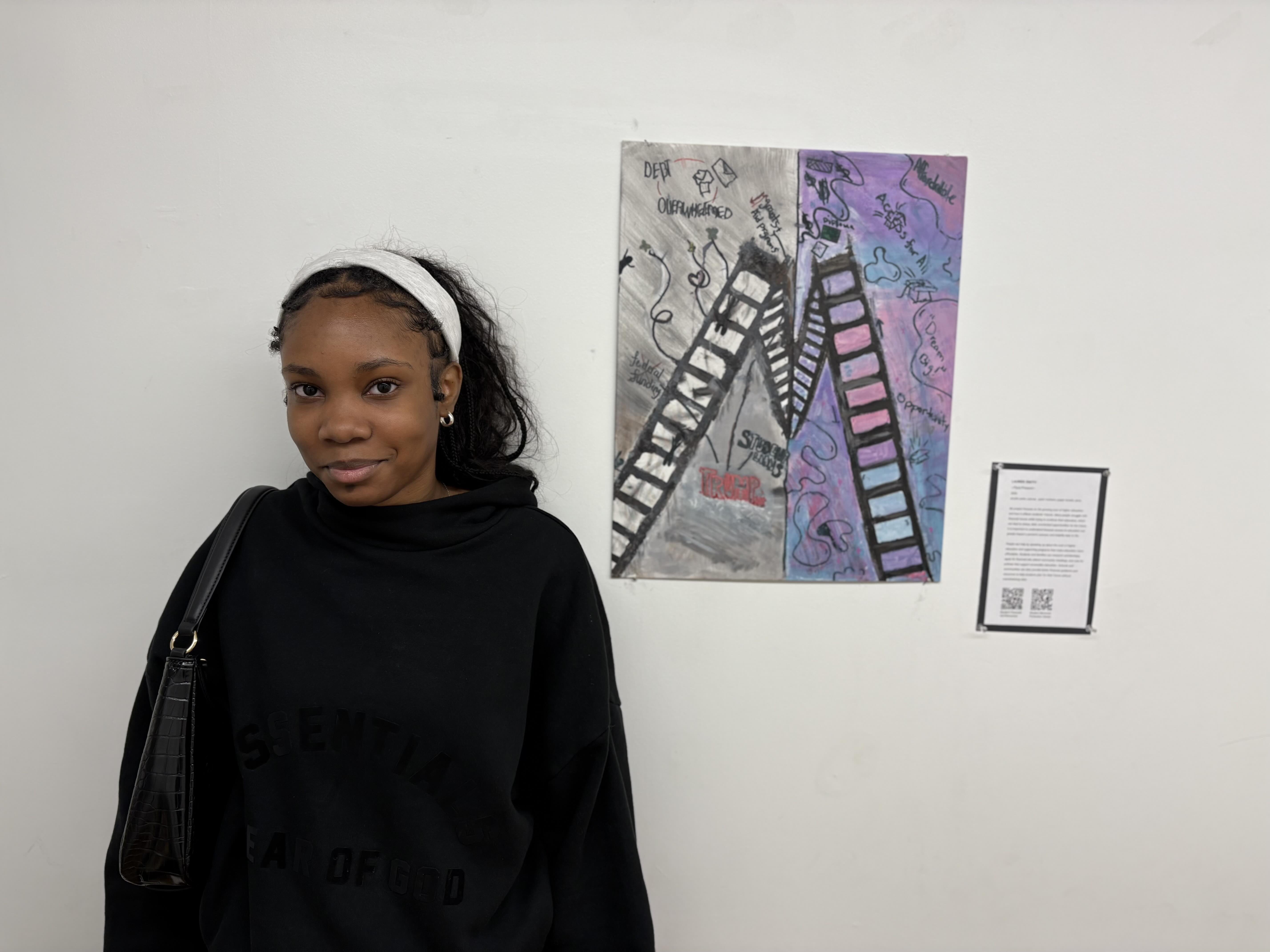 Student standing next to painting with two ladders tilting towards each other.