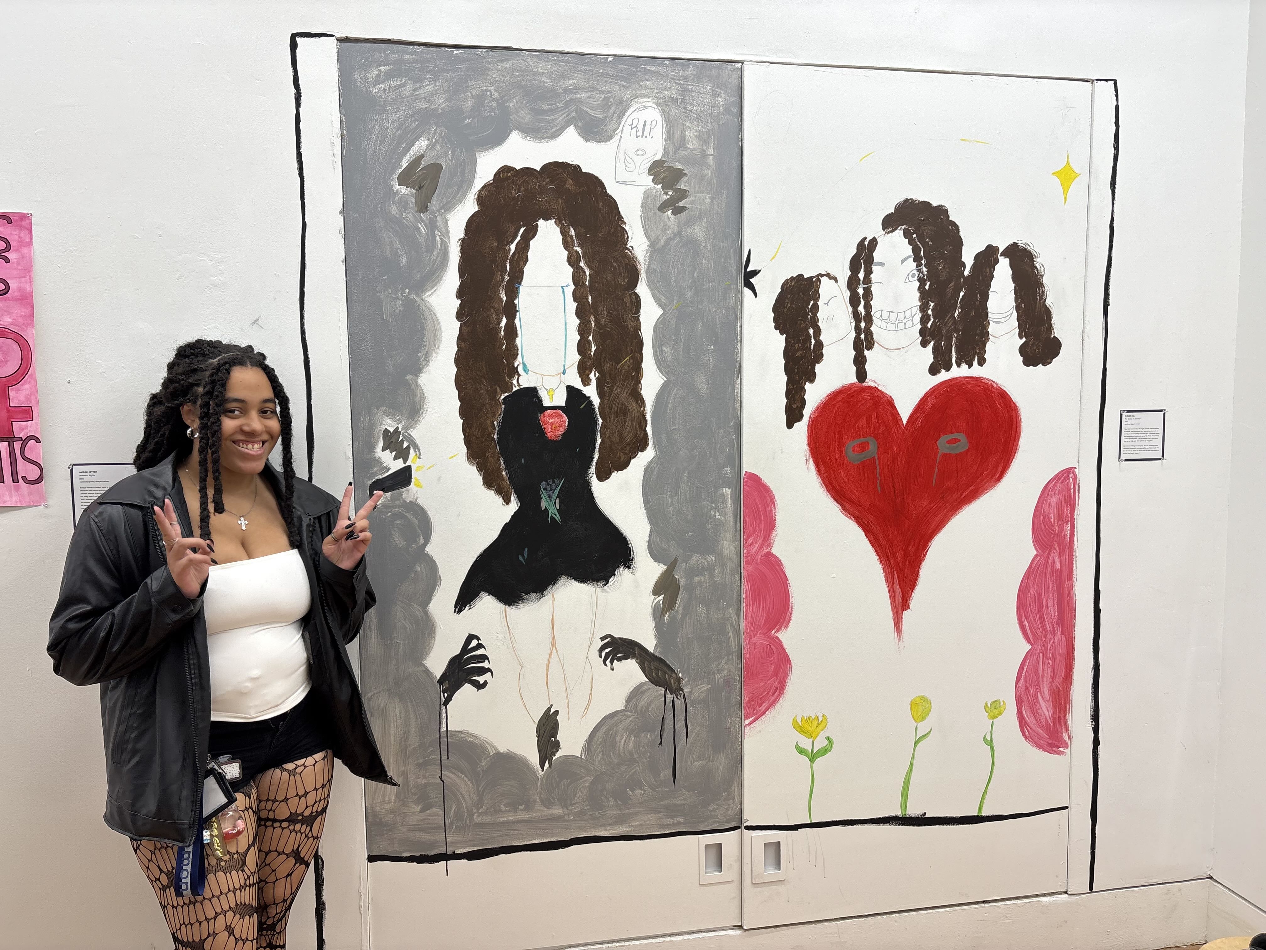 Student standing in front of painted mural.