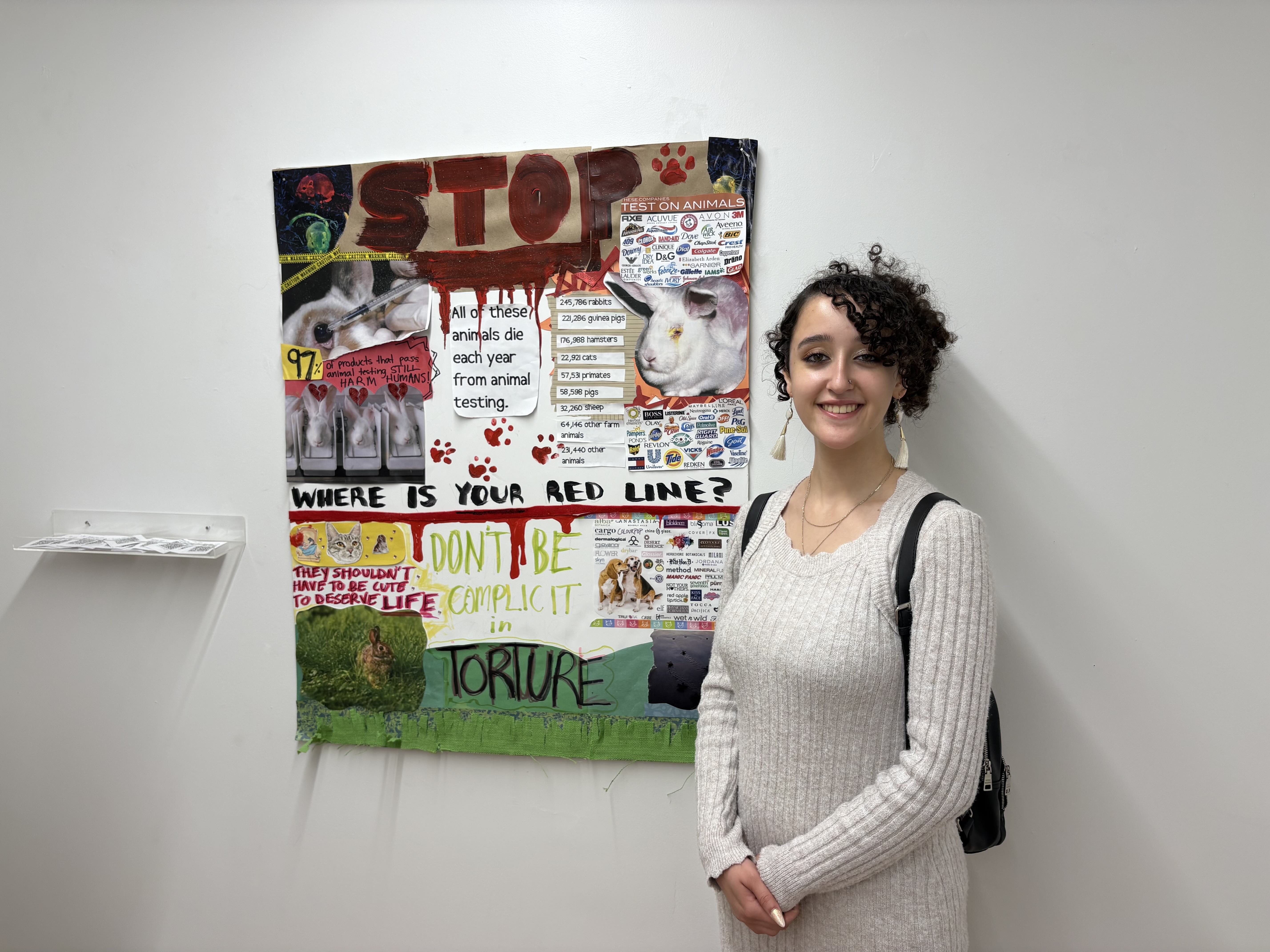 Student standing in front of mixed media collage and painting.