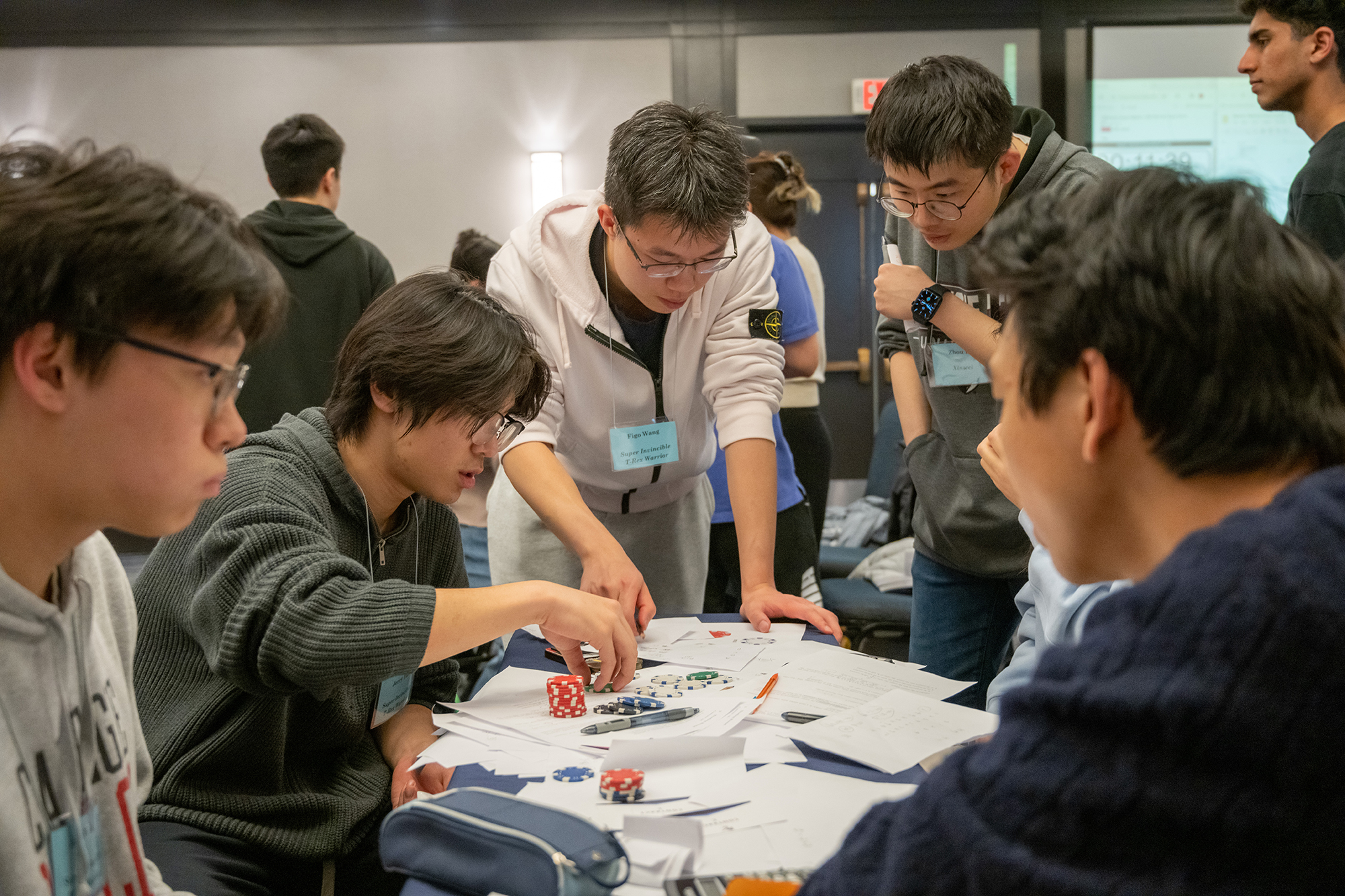 a group of students gathers around a table and discusses trades