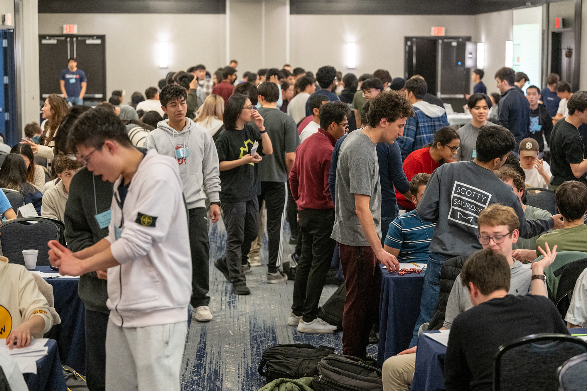 a group of students wander around a hotel ballroom